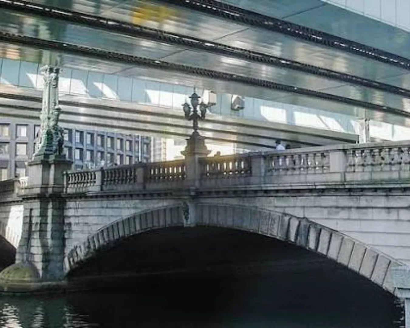 The stone Nihonbashi Bridge with lion sculptures, lamps, and an elevated expressway overhead.