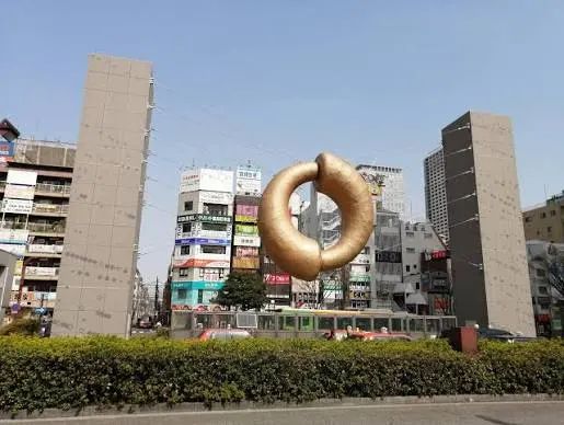 The gold ECHO monument at Kinshicho Station North Exit above the taxi stand.