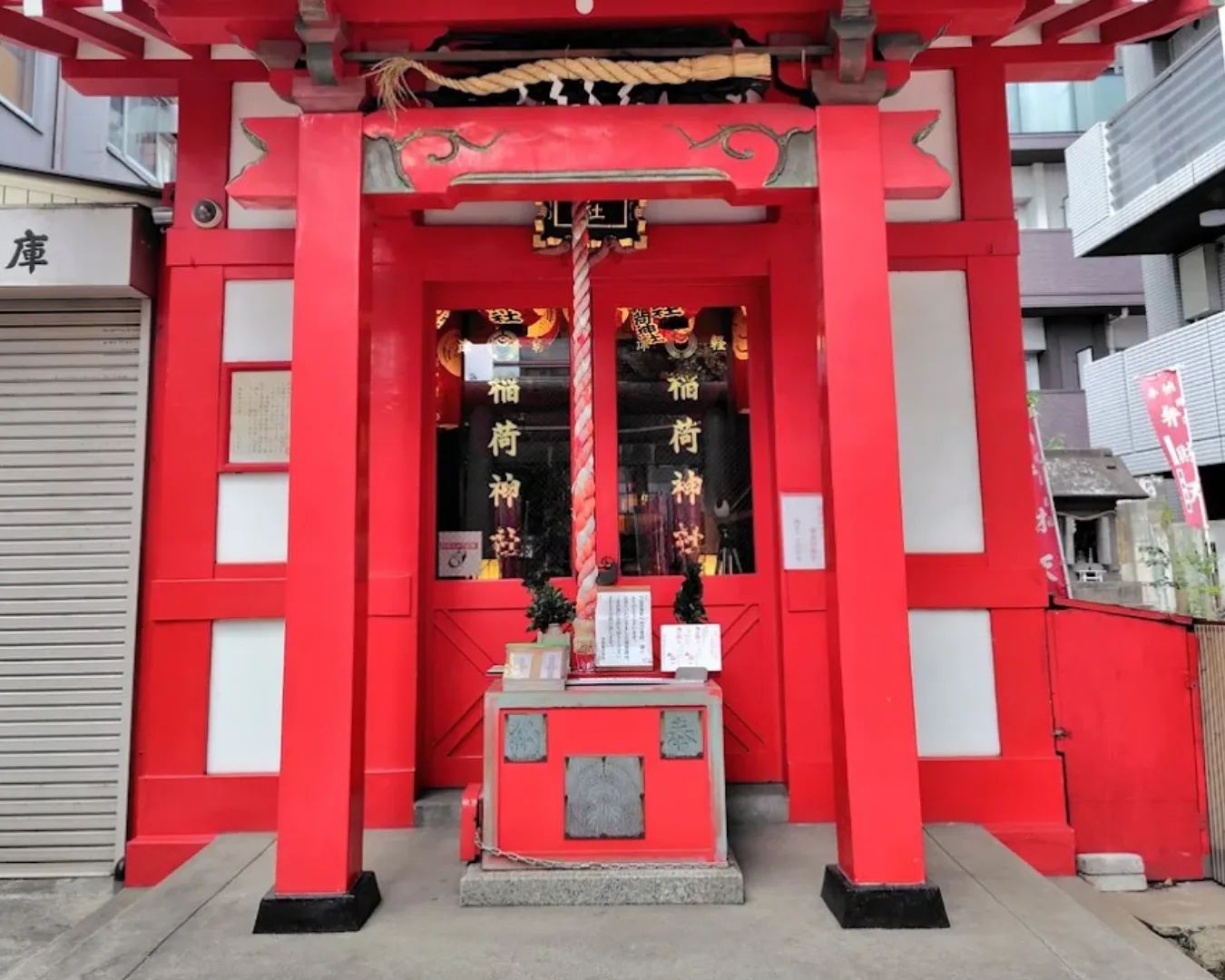Red banners and fox guardian statues at Tsugaru Inari Shrine in Kinshicho.