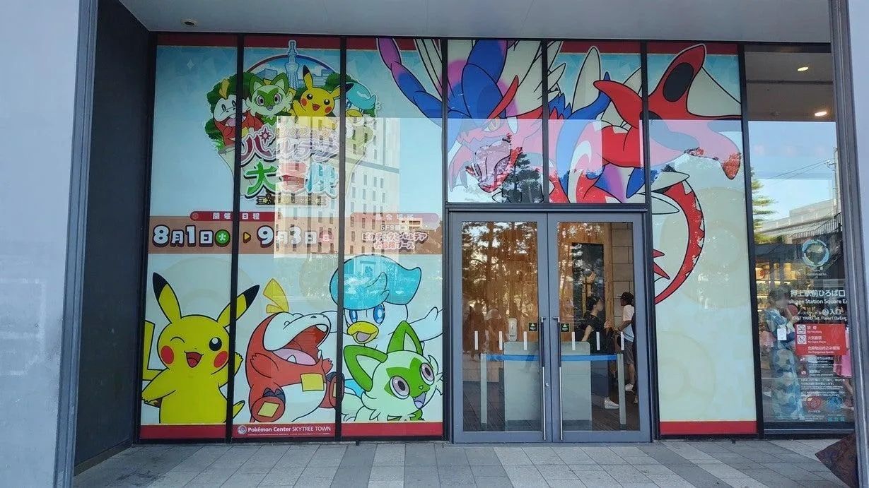 A Pokémon summer rally card held inside Tokyo Solamachi near the escalators.