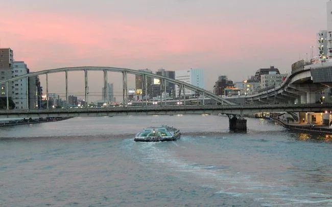 The Sumida River opening into view from the riverside promenade near Ryogoku.