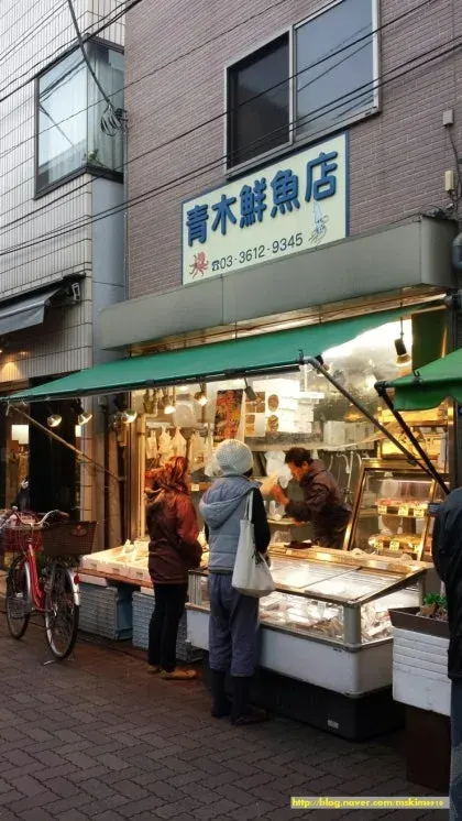 Late afternoon on Kira-Kira Tachibana Shopping Street with shutters, bicycles, and people finishing errands.